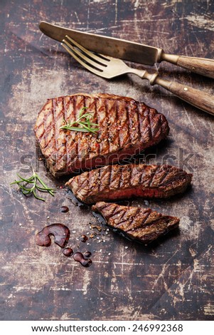 Sliced medium rare grilled Beef steak Ribeye on dark metal background