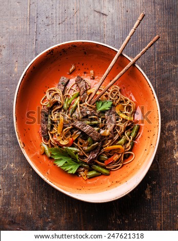 Fried noodles Yakisoba with beef on red plate