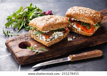 Sandwich with cereals bread and salmon on dark marble background