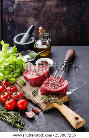 Raw fresh marbled meat Steak, seasoning and meat fork on dark marble background