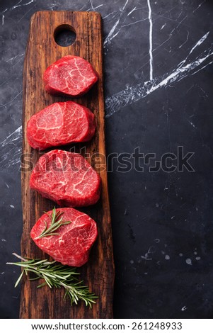 Raw fresh marbled meat Steak and rosemary on dark marble background