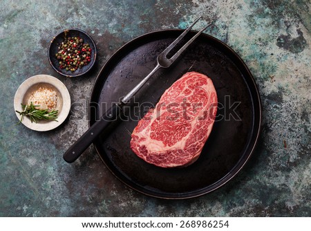 Raw fresh marbled meat Black Angus Steak and seasonings on metal background