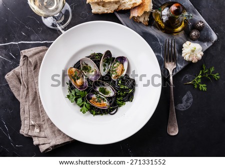 Seafood pasta with clams Spaghetti Vongole on white plate on dark marble background