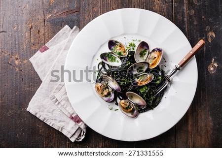 Seafood pasta with clams Spaghetti Vongole on white plate on dark marble background
