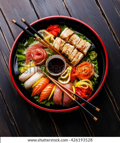 Sushi Set nigiri, rolls and sashimi served in traditional Japan black Sushioke round plate