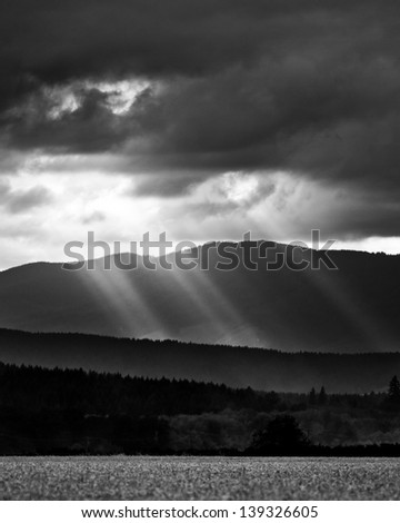 Sun beams on hills after a storm, black and white