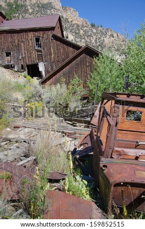 Old gold mining structure and rusted antique car at Bayhorse, Idaho ghost town.