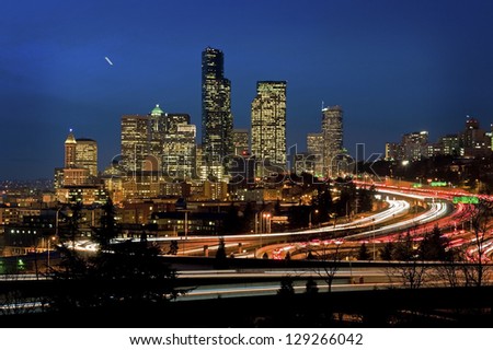 Seattle Commute. The Seattle, Washington skyline at night with Interstate 5 packed with cars and trucks during the commuter hours.