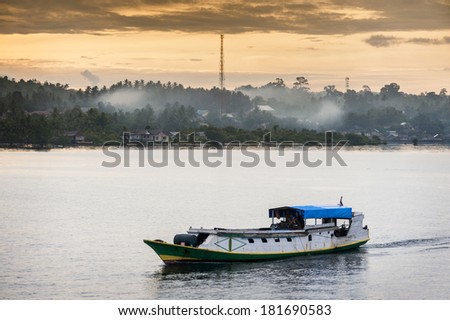 Banggai Island, Indonesia. Sunrise off of Banggai island in the Spice Island route of remote Indonesia. Fishing boats return in the morning with the days catch. Cooking fires add atmosphere.