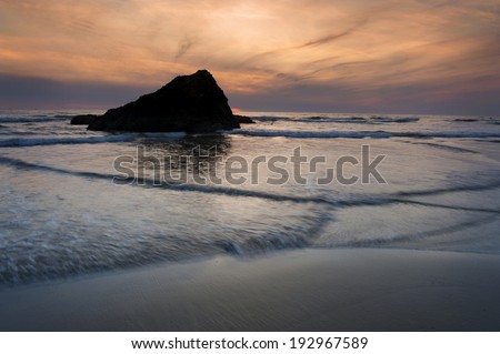 Murphys' Rock, Arch Cape, Oregon. A beautiful sunset along the Oregon coast with Murphys' Rock towering over the sandy beach.