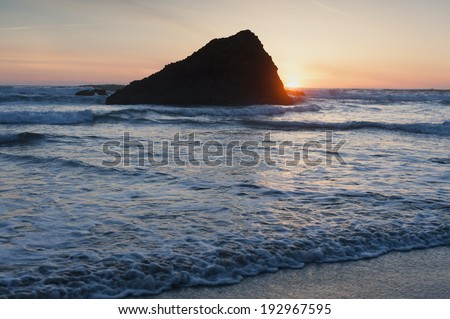 Murphys' Rock, Arch Cape, Oregon. A beautiful sunset along the Oregon coast with Murphys' Rock towering over the sandy beach.
