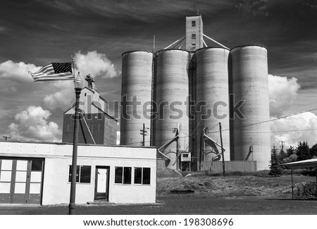 Harrington, Washington, USA. A black and white view of this rural Palouse town in eastern Washington state. Silos and American flags are the order of the day here.