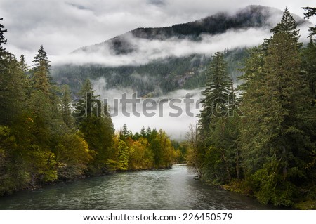 Skagit River. Low clouds and changing colors are a sure sign that fall is in full swing in the North Cascade mountains in this idyllic scene on the Skagit River in Washington state.