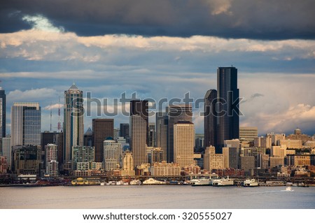 Seattle Skyline. Sunlight breaks through the clouds to illuminate a small section of Seattle\'s lovely waterfront area making for a dramatic skyline image.