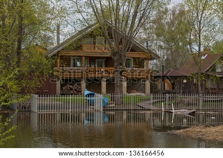 Old wooden house in the Russian tradition on the banks of the river in the village