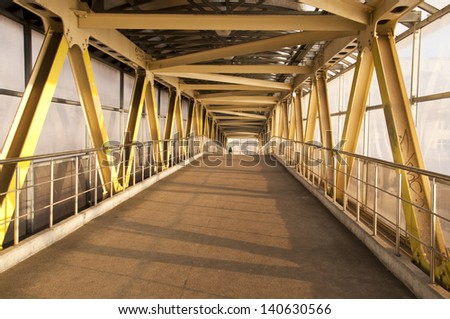 A long corridor pedestrian crossing with iron structures.