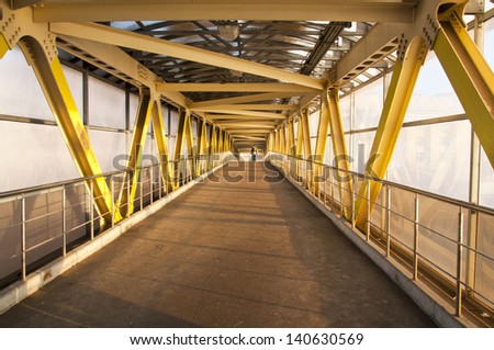 A long corridor pedestrian crossing with iron structures.