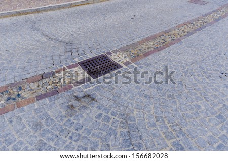 Outdoor tiles, cobblestones and storm drain on the street the Italian city