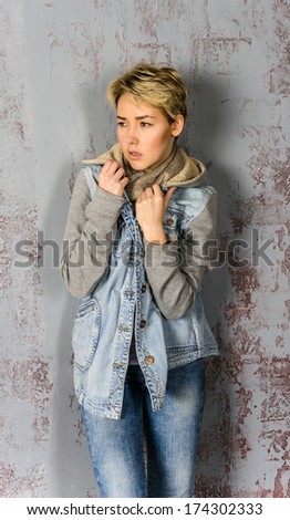 A young girl stands and basks in  and denim jacket
