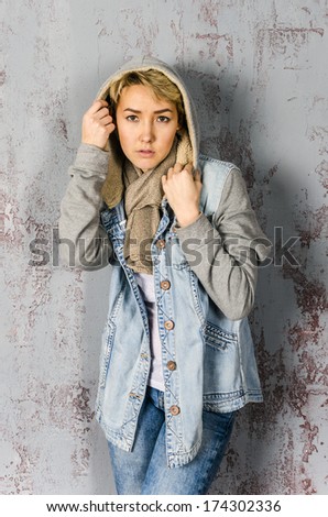 A young girl stands and basks in  and denim jacket