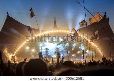 ROSKILDE, DENMARK - JULY 2 Audience with flags and banners, raising their hands in front of the stage at Roskilde Festival 2015. Roskilde Festival is one of the largest music festivals in Europe.