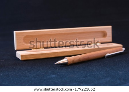 Wooden ball pen with case on a dark background