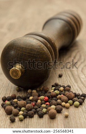 Pepper corns of different types with pepper mill