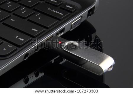Flash memory drive plugged into a laptop port.