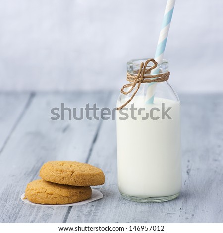 Very sweet retro bottle of milk with cookie on old table
