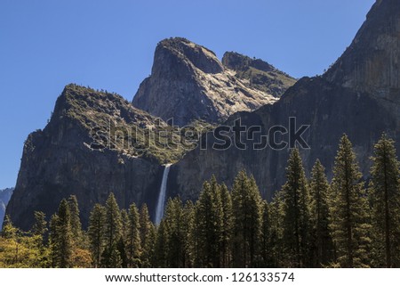 An image of the peaks known as the The Three Brothers and Bridalveil Falls under clear blue skies.