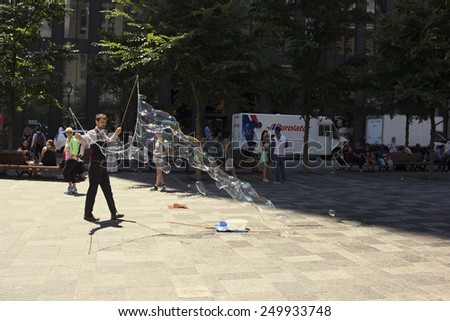 MONTREAL/CANADA - JULY 11, 2014: Street performer making giant bubbles on Place d\'Armes in Old Montreal in Canada.