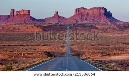 Highway 163 descending into Monument Valley, Utah / Arizona border. The massive distant buttes of Monument Valley are approximately 1000\' tall, roughly the height of a 100-story building.