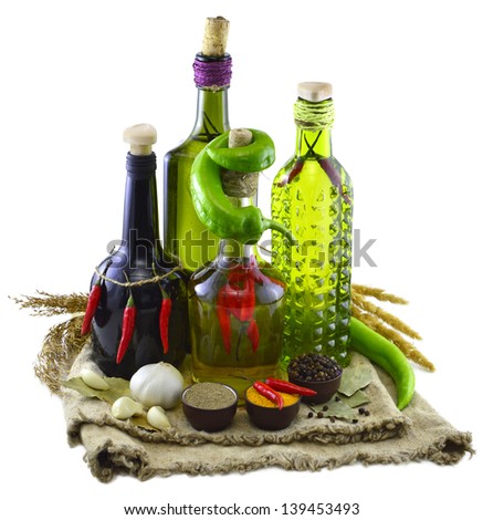 Four bottles with peppers and spices on burlap bags isolated