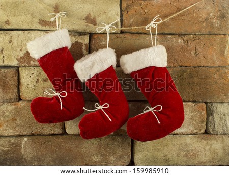 Three red Santa boots on chimney place background