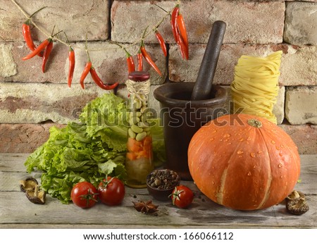 Kitchen still life with vegetables and old dishware on brick wall background