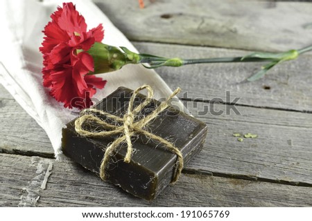 Red flower with black soap on wooden table