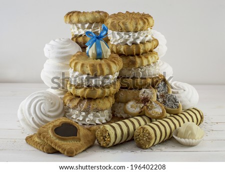 Heap of fancy cakes with cookies, marshmallows and white chocolate candy on top