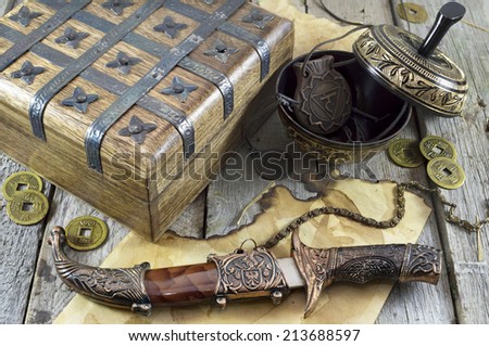 Wooden box, knife and medallions on wooden background