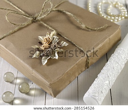 Close up of vintage gift box in wrapped brown paper on wooden planks