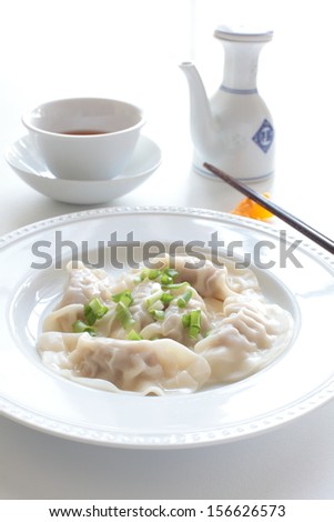 Plate of cooked chinese dumpling with chopstick