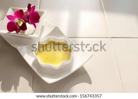 Tray with aroma oil in bowl and orchid flowers