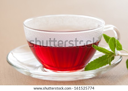 A steamy cup of tea in a clear cup.