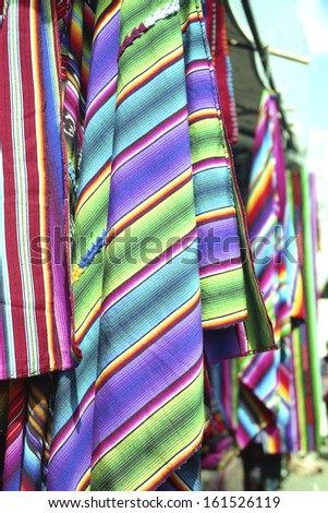 Multi-colored cloths hanging from a tent.