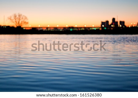 A lake with a city in the background at dusk.