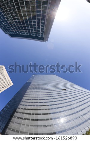 Low angle of two skyscrapers with blue sky at the top.