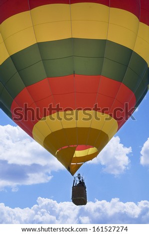 A colorful hot air balloon flying on a sunny day.