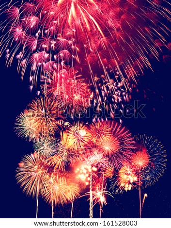 Exploding fireworks lighting up a night sky.