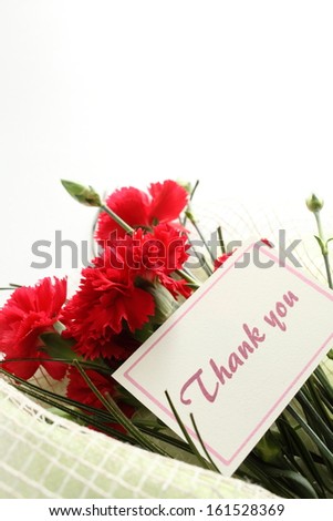 A bouquet of red carnations and a thank you note.