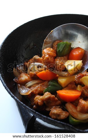 Chicken and fresh vegetables simmering in a cast iron skillet.