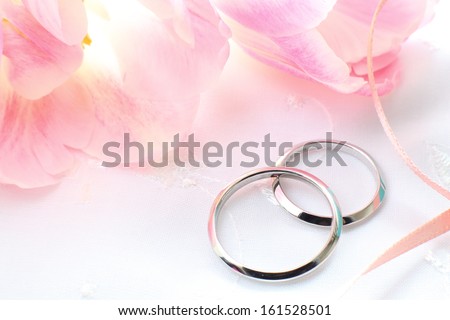 Wedding bands with pink flowers and ribbon.